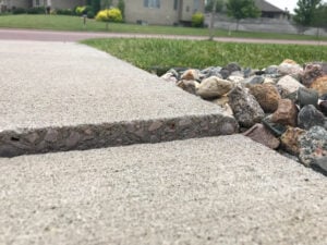 Image of a concrete sidewalk that needs leveling and repair.