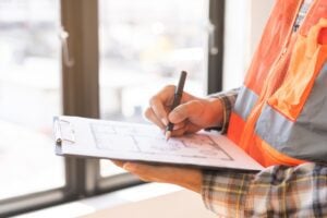 image of a man taking notes during an inspection. Read the article to learn how polyjacking for building inspections can benefit you and your company.