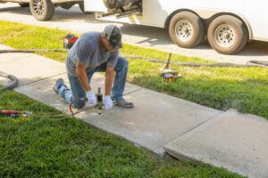 image of a polyjacking contractor performing work on a sidewalk